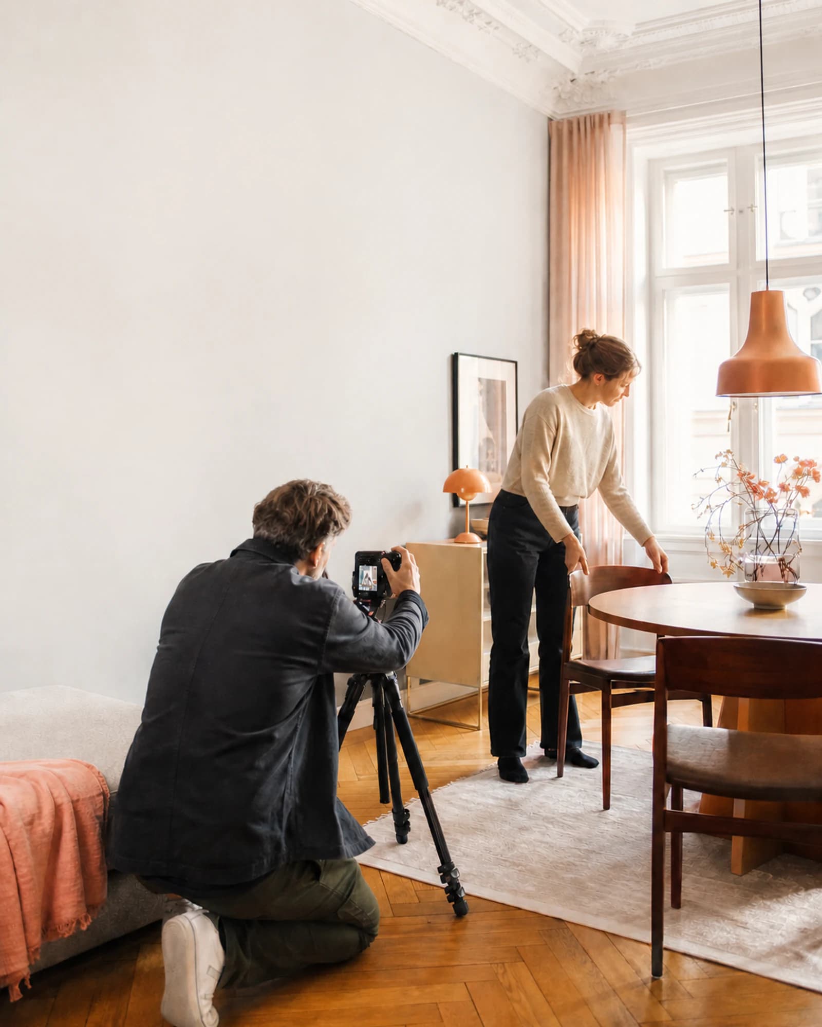 Immobilienfotograf und Eigentümerin bereiten eine helle Wohnung für den Verkauf vor